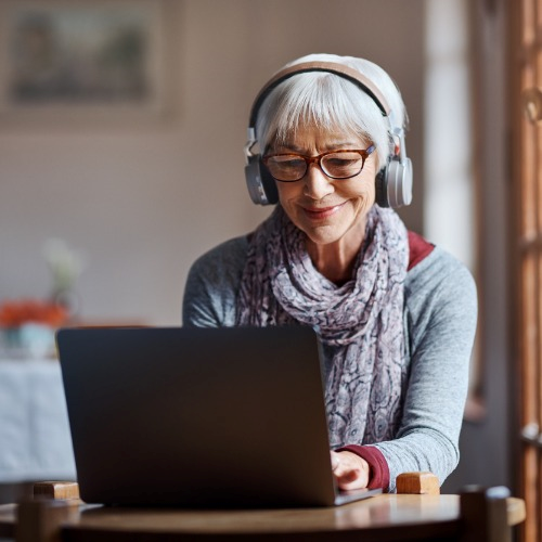 senior woman listening to music in front of pc